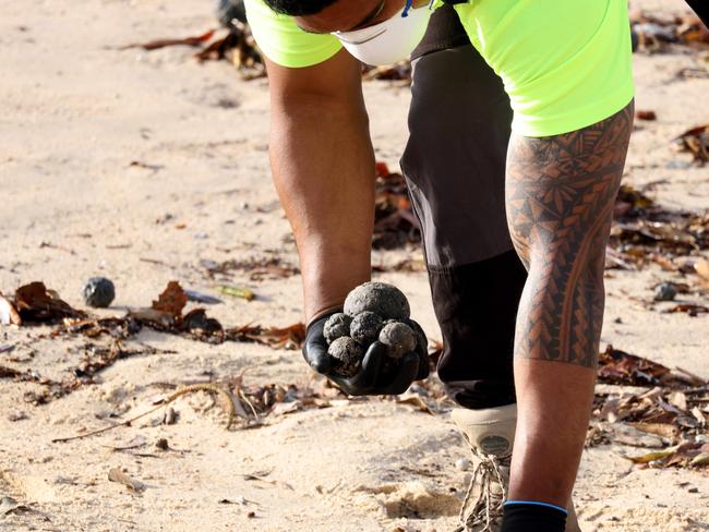 SYDNEY, AUSTRALIA - NewsWire Photos OCTOBER 16, 2024: Council workers clean up what Randwick council describes as possible tar balls that have washed up on Coogee Beach. Coogee Beach has been closed until further after mysterious, black, ball-shaped debris was located washed along the length of the beach.Picture: NewsWire / Damian Shaw