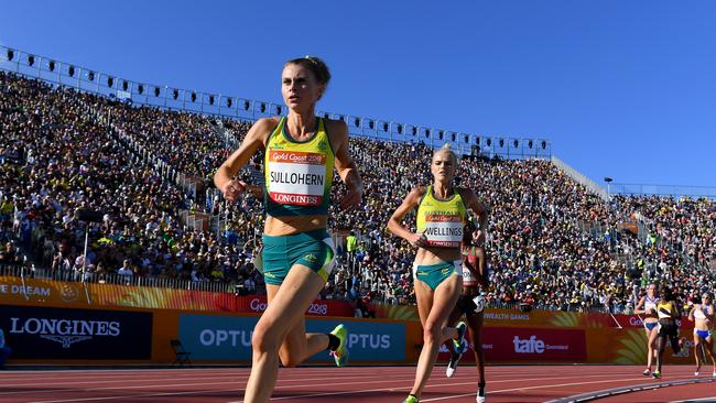 Celia Sullohern (left) and Eloise Wellings of Australia compete in the Women's 5000m Final on day ten of the XXI Commonwealth Games, at Carrara Stadium. Behind them a stand created for the event. (AAP Image/Dean Lewins).