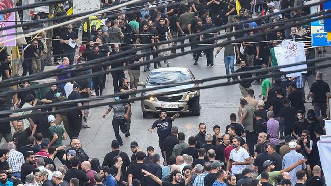 People react around a car after an explosion during the funeral on Wednesday of those killed by exploding pagers on Tuesday. Picture: AFP