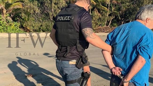 Peter Foster in handcuffs on a beach at Port Douglas following his arrest this morning. Picture: IFW Global/Twitter