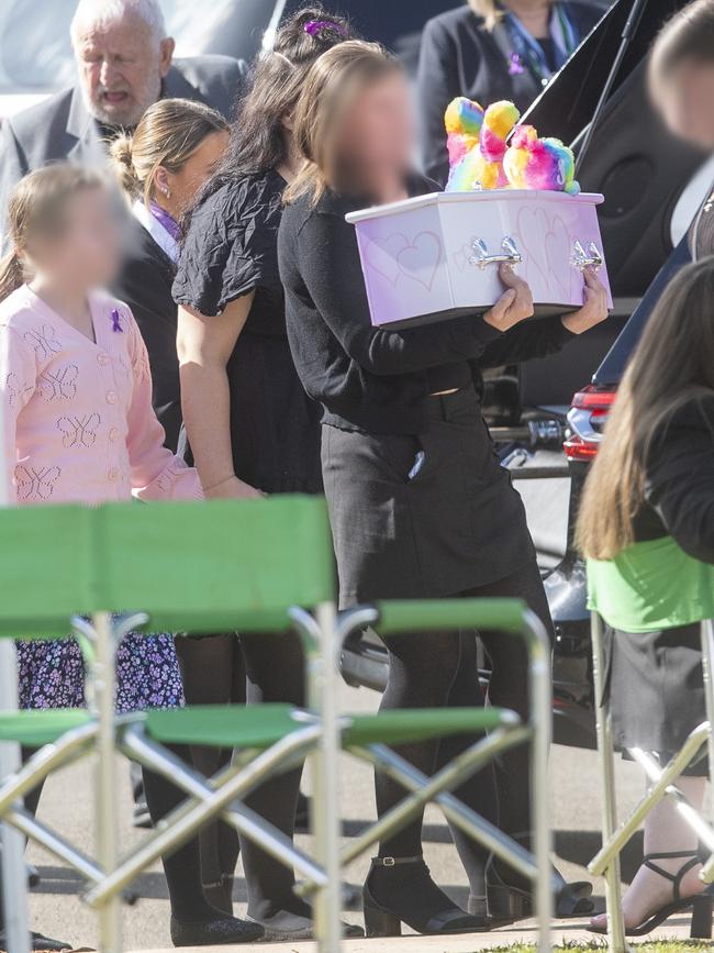 Their mother carries the coffin of her youngest of the three children killed.