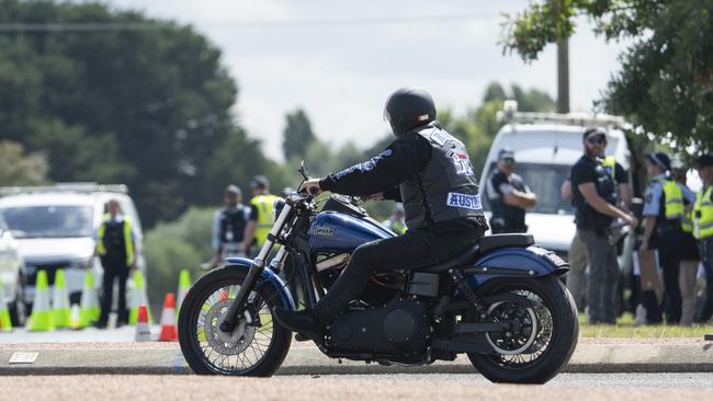 A Rebels member motors past police. Picture: Martin Ollman