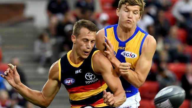 Adelaide's Tom Doedee gets a kick away under pressure from the West Coast's Brayden Ainsworth. Picture: AAP Image/Sam Wundke