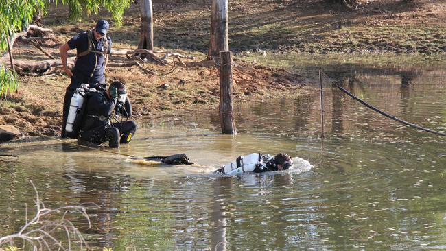 Police divers search a lake on Palmerville Station during investigations into the disappearance of Bruce Schuler.