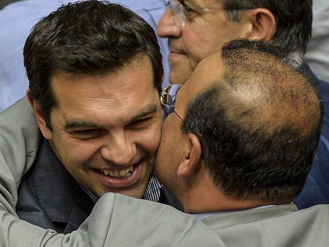 Greek Prime Minister Alexis Tsipras (C) it's congratulated by coalition members at the end of a session at the Greek Parliament in Athens on July 10, 2015. Lawmakers in Greece are to vote whether to back a last-ditch reform plan the government submitted to creditors overnight in a bid to stave off financial collapse and exit from the Eurozone. Greece's international creditors believe its latest debt proposals are positive enough to be the basis for a new bailout worth 74 billion euros, an EU source said June 10. . AFP PHOTO / ANDREAS SOLARO