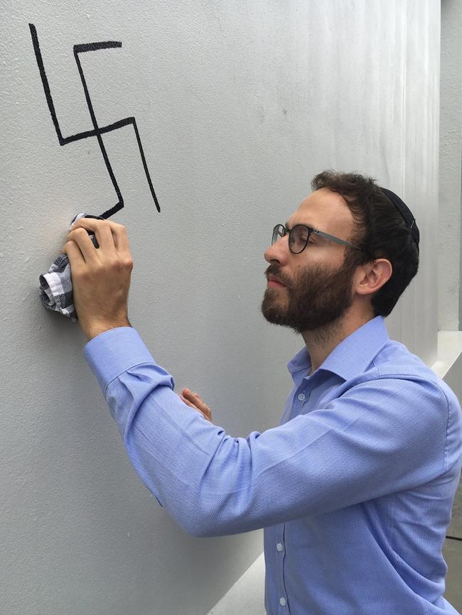 Rabbi Friedman removes the graffiti. Picture: Facebook