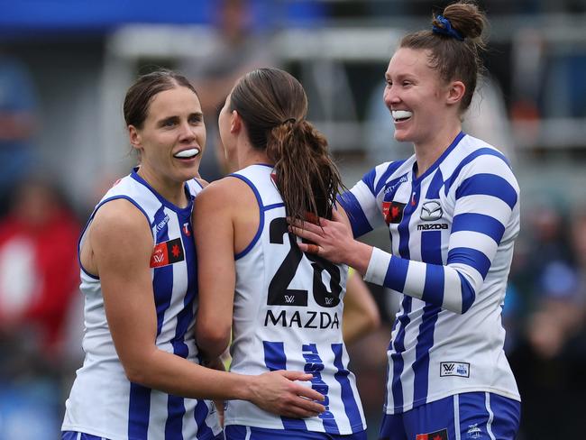 Niamh Martin of the Kangaroos celebrates with Jasmine Garner and Tahlia Randall.