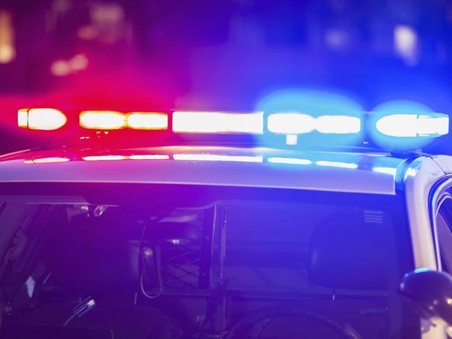 The roof of a police patrol car at night, with the blue and red lights flashing.