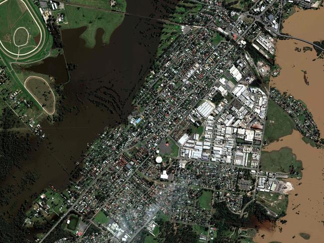 (COMBO) This combination of handout satellite imagery released on March 25, 2021, by Maxar Technologies shows the aftermath of floods (top) in Windsor, Australia, on March 25, 2021, as compared to the same area on January 24, 2021 (bottom). - Thousands of flood-stricken residents along Australia's east coast began a massive clean up effort Thursday, as waters receded revealing damaged homes, piles of debris and mud-caked roads. The region has been devastated by widespread flooding brought on by a torrential downpour, inundating towns, destroying farmland and leaving two people dead. (Photos by - / Satellite image Â©2021 Maxar Technologies / AFP) / RESTRICTED TO EDITORIAL USE - MANDATORY CREDIT "AFP PHOTO / Satellite image Â©2021 Maxar Technologies" - NO MARKETING - NO ADVERTISING CAMPAIGNS - DISTRIBUTED AS A SERVICE TO CLIENTS