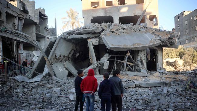 TOPSHOT - Palestinian children stare at a building destroyed in an Israeli airstrike in Nuseirat in the central Gaza Strip on December 1, 2024, amid the ongoing war between Israel and Hamas militants. (Photo by Eyad BABA / AFP)