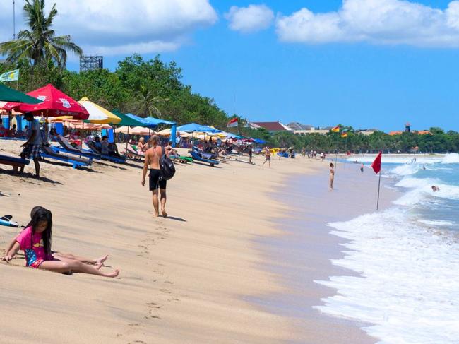 People relax on a beach in Kuta. Picture: Kuta