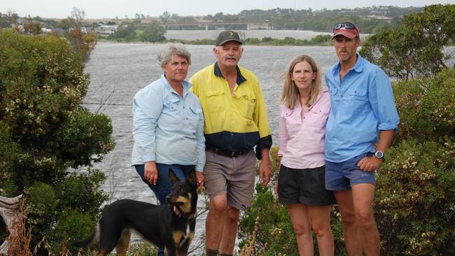 Joanne and Barry Pfeiffer with Alex and Mark Westlake stand in front of their farm at Murray Bridge which is underwater after the Long Flat levee breached on January 7. Photo: Dylan Hogarth.