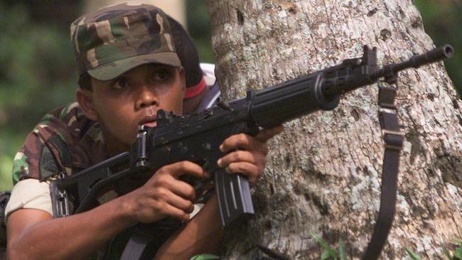 Indonesian soldier engages Acehnese rebels in 2003.