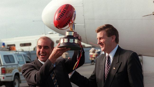 Premier John Olsen holding the Premiers Cup with Jeff Kennett at Adelaide Airport after the Adelaide Crows won the 1997 AFL premiership. Picture: File