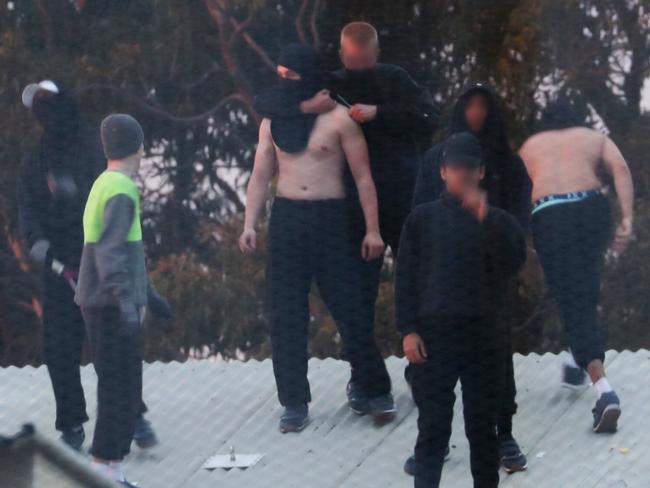 Inmates from the Frank Baxter Juvenile corrections centre Kariong taunt police from the roofs of various buildings. Picture: John Grainger