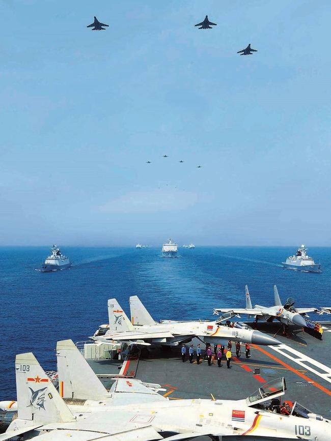 A formation of Chinese J-15 “Flying Shark” fighters fly over the aircraft carrier Liaoning during a fleet review attended by Chairman Xi Jinping.