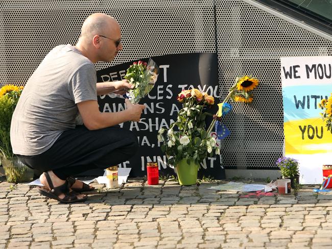 A visitor places flowers at a temporary memorial for the victims in Berlin.