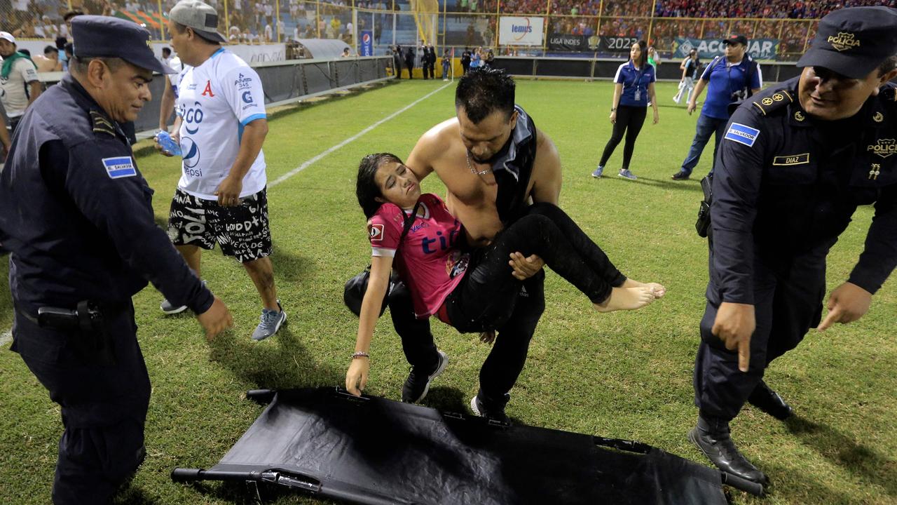 Those who avoided the crush helped the injured on the pitch. Picture: Milton Flores/AFP