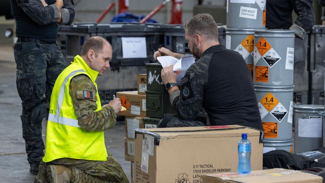 A member of the 1st Joint Movement Unit checks cargo alongside a Australian Federal Police Special Operations member, prior to their departure from Canberra to the Solomon Islands.