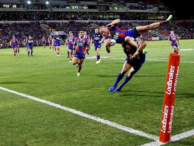 Winger Nathan Ross flies through the air to score a spectacular try for the Knights. Picture: Peter Lorimer