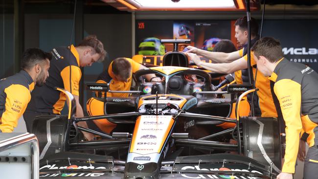 McLaren team mechanics work on putting Oscar Piastri race car together. Picture: David Caird