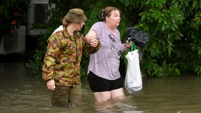 CPT Stacey Brown helps Robin Webb from her house after she returned to see the devastation in Townsville. Picture: Alix Sweeney