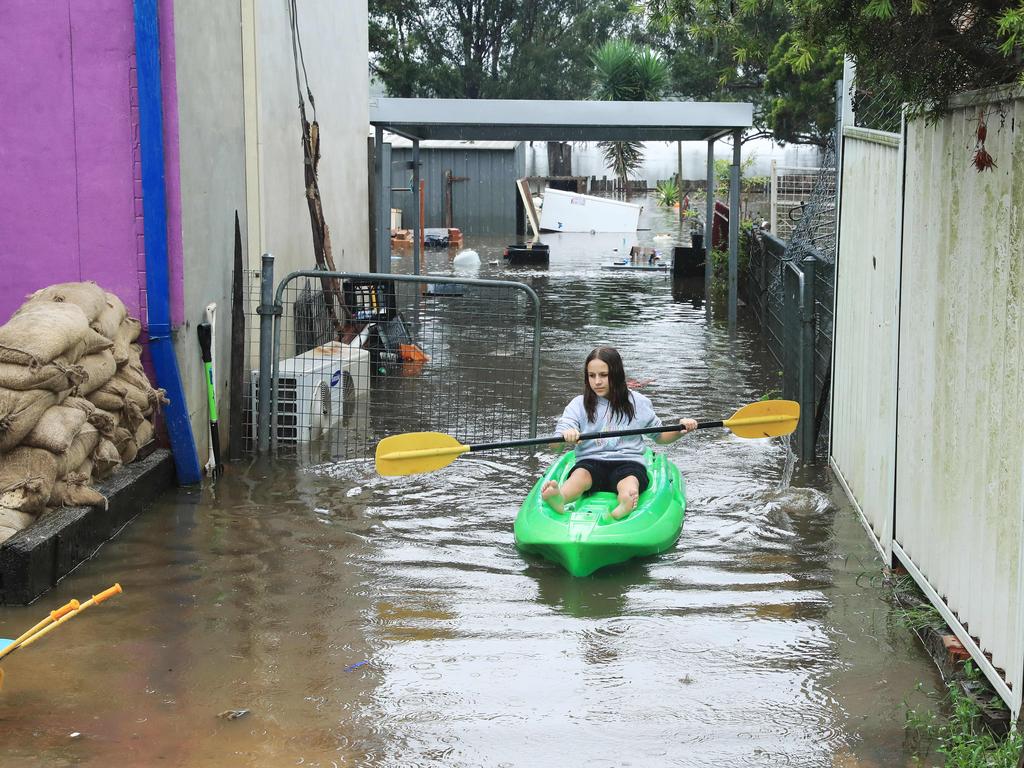 22/3/21: Chloe Panman checks her rabbits at her house at Church street in Windsor which is flooded. John Feder/The Australian