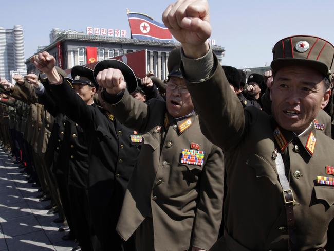 North Korean army officers punch the air as they chant slogans during a rally.