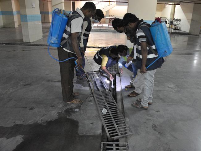 Municipal workers conduct anti-mosquito operations at a school in Secunderabad, the twin city of Hyderabad, on September 5, 2019. - The Greater Hyderabad Municipal Corporation (GHMC) is conducting an operation to combat water-borne diseases like dengue and malaria in the region. (Photo by NOAH SEELAM / AFP)