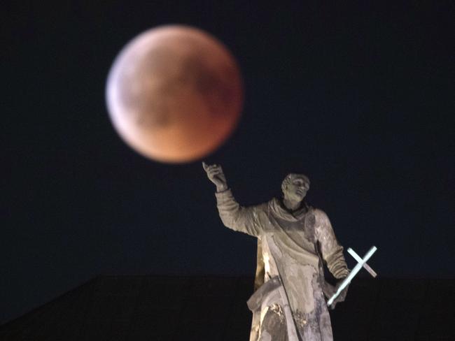 The moon turns red during a total lunar eclipse, as seen from Dresden, Germany. Picture: AP