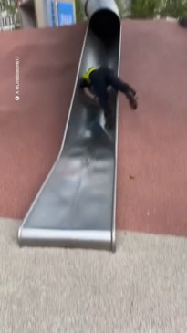 Cop tumbles down playground slide