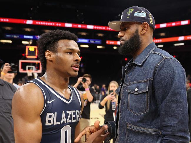 (FILES) Bronny James, #0 of the Sierra Canyon Trailblazers, is greeted by his father and NBA player LeBron James after defeating the the Perry Pumas in the Hoophall West tournament at Footprint Center in Phoenix, Arizona, on December 11, 2021. NBA superstar LeBron James said on July 27, 2023, his family was "together, safe and healthy" four days after his eldest son suffered cardiac arrest during practice with his college basketball team. (Photo by Christian Petersen / GETTY IMAGES NORTH AMERICA / AFP)