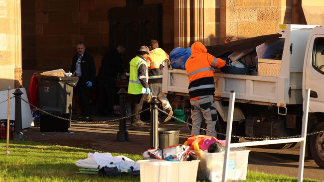 University staff packing down unattended items in a move protesters say is “egregious form of soft repression”. Picture: Rohan Kelly