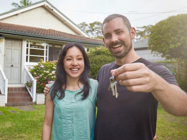 Happy mixed-race couple showing the keys of the new house. Home housing unlocking equity generic