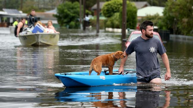 Dave Soury with his dog Scout at North Haven, south of Port Macquarie, which was inundated with flood waters on Saturday. Picture: Nathan Edwards