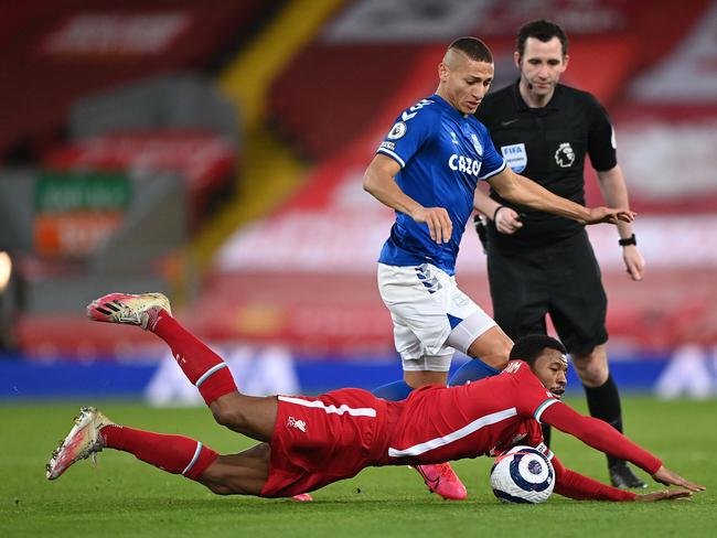 Liverpool's Dutch midfielder Georginio Wijnaldum (down) vies with Everton's Brazilian striker Richarlison during the English Premier League football match between Liverpool and Everton at Anfield in Liverpool, north west England on February 20, 2021. (Photo by Laurence Griffiths / POOL / AFP) / RESTRICTED TO EDITORIAL USE. No use with unauthorized audio, video, data, fixture lists, club/league logos or 'live' services. Online in-match use limited to 120 images. An additional 40 images may be used in extra time. No video emulation. Social media in-match use limited to 120 images. An additional 40 images may be used in extra time. No use in betting publications, games or single club/league/player publications. /