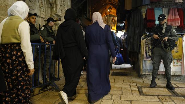 Israeli police border officers stand guard as Muslim women attend a prayer at Al-Aqsa mosque during the first day of the Ramadan in Jerusalem.