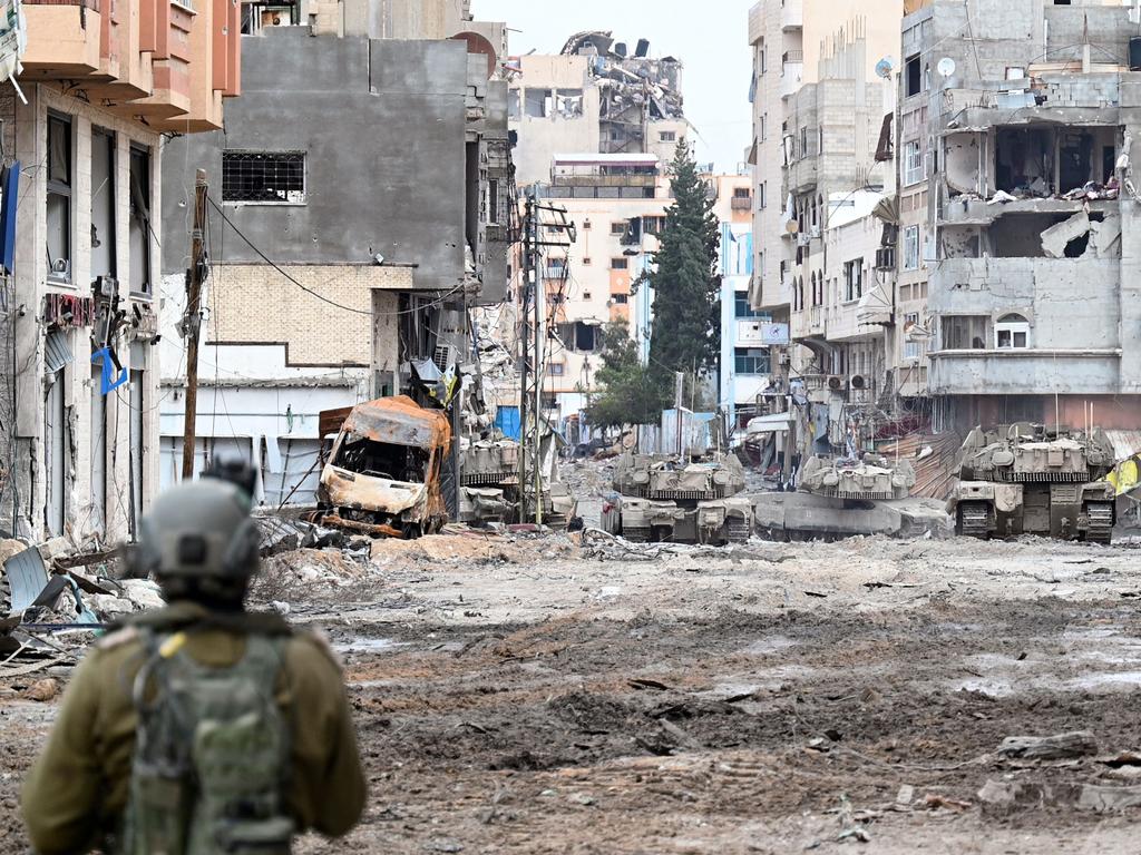 Israeli tanks roll along a badly damaged street during a military operation in the northern Gaza Strip on November 22 ahead of the ceasefire. Picture: Ahikam Seri/AFP