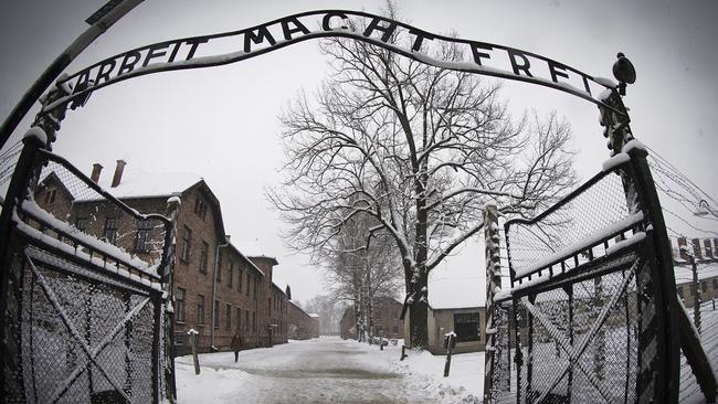 A woman walks through snow near the entrance to the former Nazi concentration camp Auschwitz-Birkenau. Picture: Joel Saget