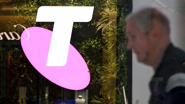 A man walks past the office of Australian telecoms company Telstra in the central business district of Sydney on May 21, 2024. Leading Australian telecoms company Telstra said May 21 it would slash up to 2,800 jobs, shedding nine percent of its workforce as it keeps pace with "rapid advances in technology". (Photo by Saeed KHAN / AFP)