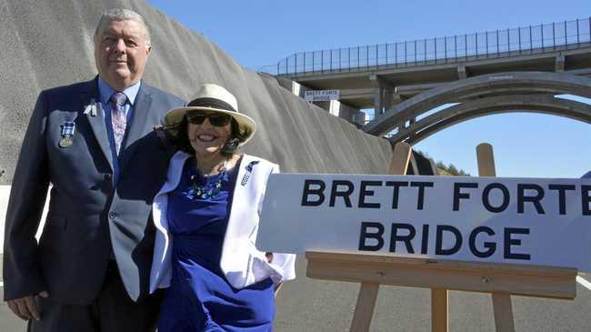 BRIDGES NAMED: Stuart and Heather Forte, the parents of police officer Brett Forte who died in the line of duty in 2017, with the Brett Forte Bridge in the background. Picture: Tobi Loftus