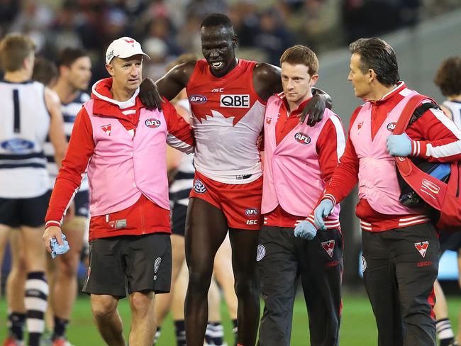 Aliir Aliir is helped off the ground after injuring his knee against the Cats. Picture. Phil Hillyard