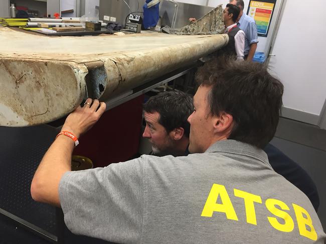 Malaysian and Australian investigators in Canberra examining a piece of aircraft debris found on Pemba Island off the coast of Tanzania. Picture: ATSB/AFP