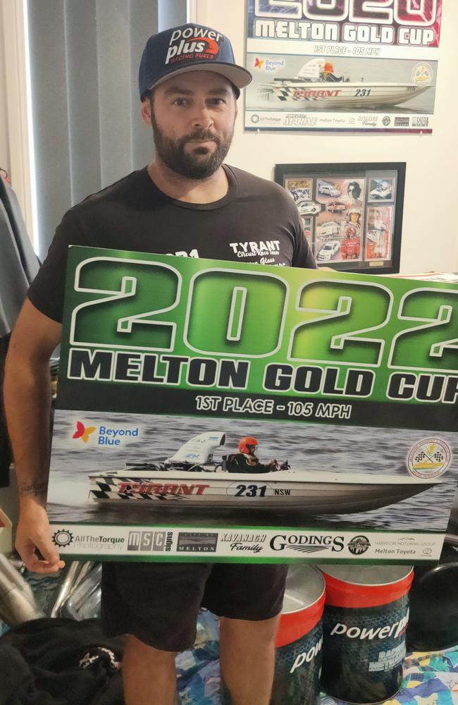 Nathan Arnold holds up the family's recent race win, the Melton Gold Cup.