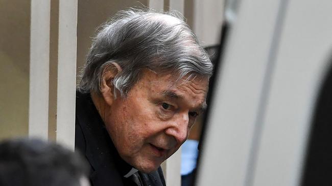 Australian Cardinal George Pell (C) is escorted in handcuffs from the Supreme Court of Victoria in Melbourne on August 21, 2019. - Disgraced Catholic Cardinal George Pell was sent back to jail after an Australian court rejected his landmark appeal against convictions for child sex abuse. (Photo by William WEST / AFP)