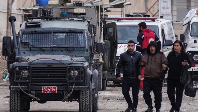 Palestinians go about their business in Jenin amid the raid. Picture: AFP