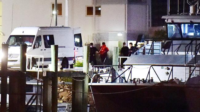 Four men get escorted the Water Police’s Brett Irwin boat after they allegedly broke strict biosecurity laws by entering to Palm Island. Picture: Alix Sweeney