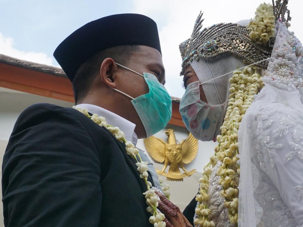 An Indonesian groom and bride wearing face masks as required during a wedding in Tangerang, Banten, amid concerns over the COVID-19 coronavirus outbreak. Picture: AFP