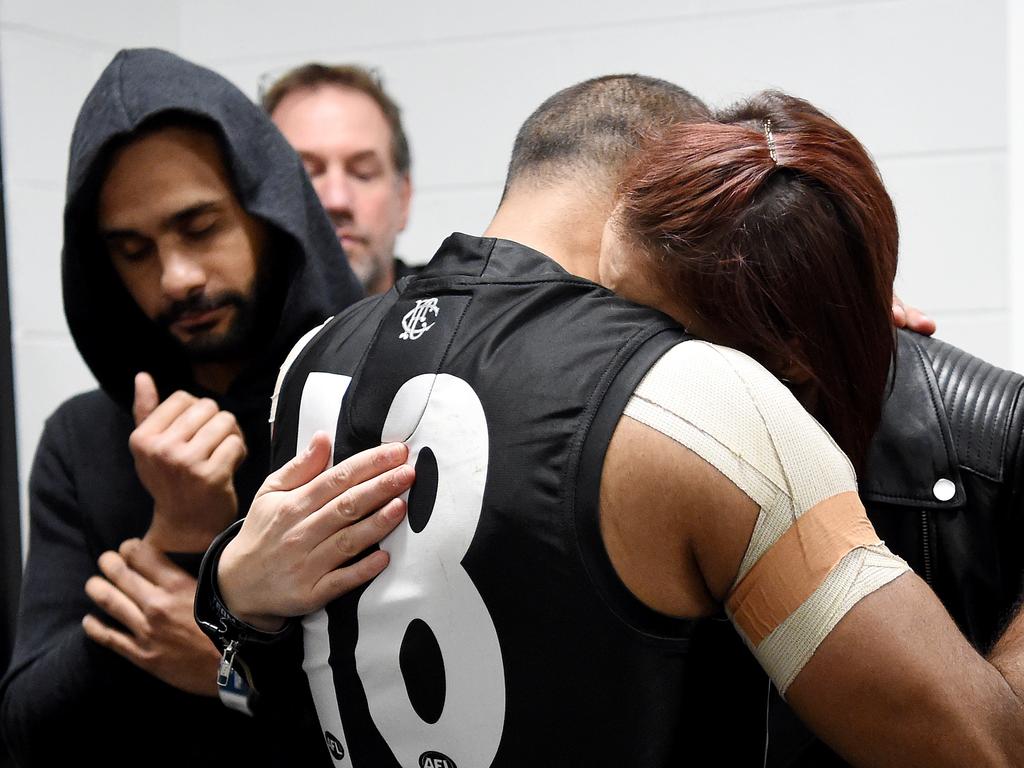 Travis Varcoe is comforted by loved ones. Picture: Nicole Garmston