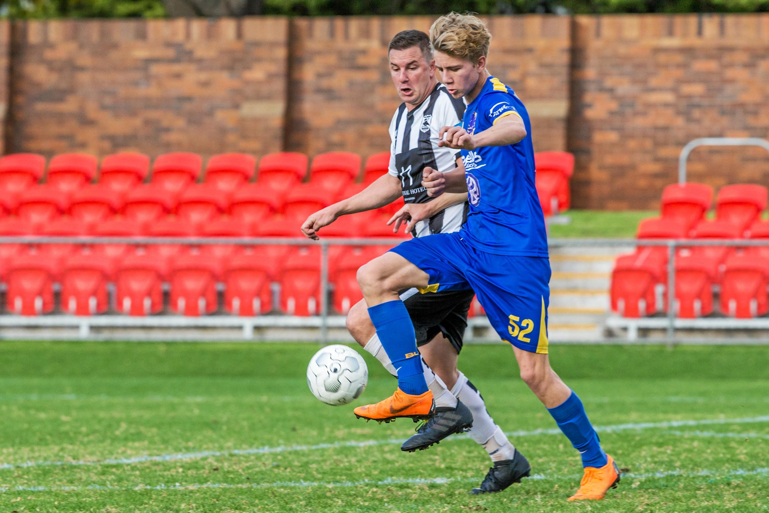 Willowburn's Rhett Greenslade (left) puts pressure on USQ FC's Cormac McCarthy. Picture: Paul Smith